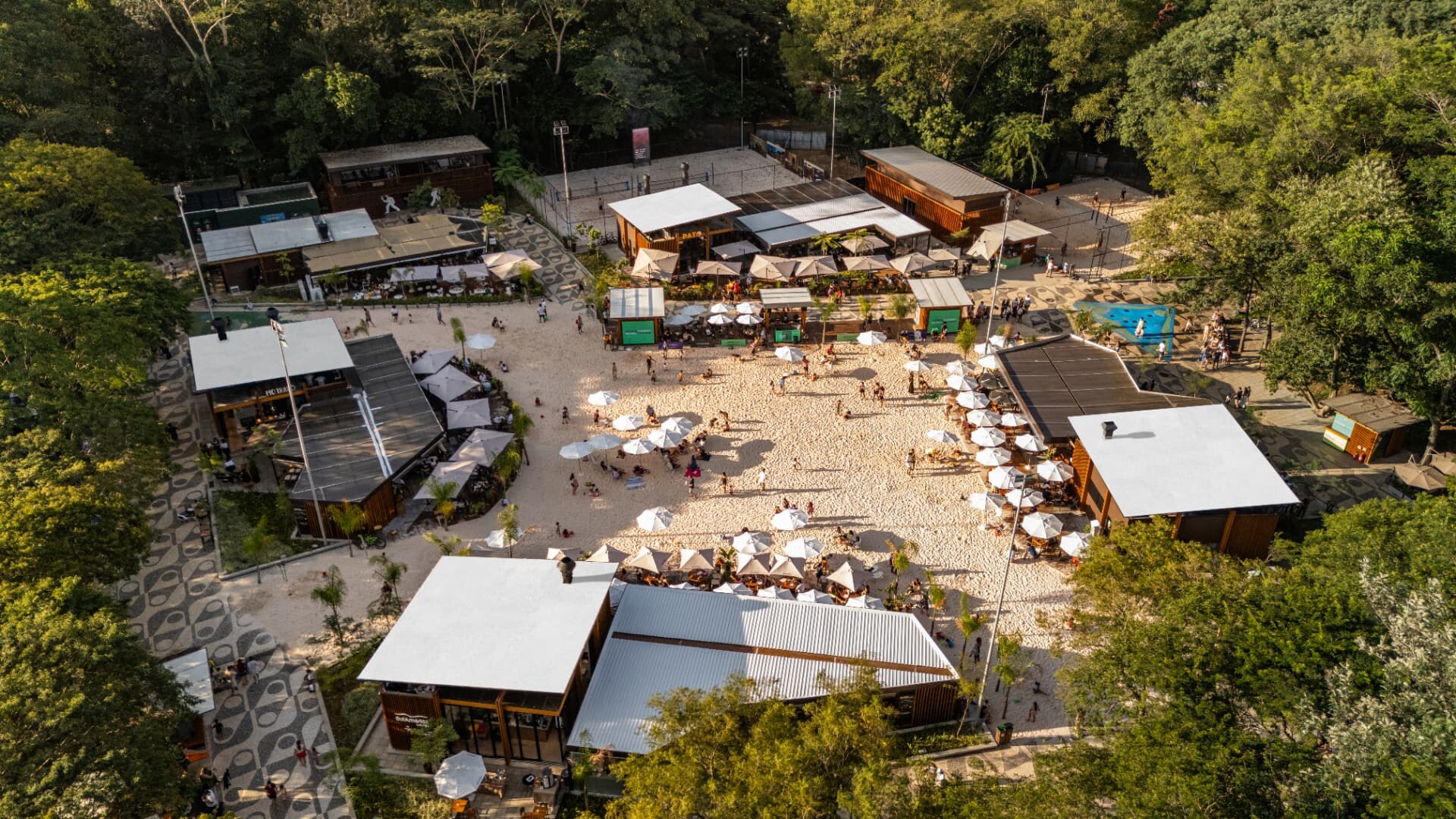 Vista aérea da Orla TotalPass no Parque Villa-Lobos com quadras de areia, quiosques e guarda-sóis